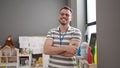 Young caucasian man working as teacher smiling with crossed arms at kindergarten Royalty Free Stock Photo