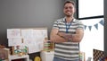 Young caucasian man working as teacher smiling with crossed arms at kindergarten Royalty Free Stock Photo