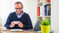 A young caucasian man working on a desk with a laptop and mobile phone. Royalty Free Stock Photo