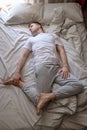 Young caucasian man working out at home at the bed doing Spinal Twist Royalty Free Stock Photo