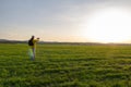 Young caucasian man in yellow jacket with backpack taking photo with mobile phone at sunset in czech spring landscape Royalty Free Stock Photo