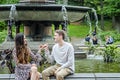 Young Millennial couple pinky promising by fountain