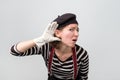 Young caucasian mime woman doing a hearing gesture