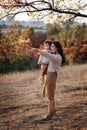 Young Caucasian mother with a boy child son baby in her hands walking and smiling in the autumn in nature Royalty Free Stock Photo