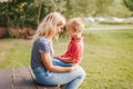 Young Caucasian mother and boy toddler son sitting together face to face. Family mom and child talking communicating outdoor on a Royalty Free Stock Photo