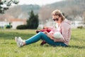 A young caucasian mother sits on the grass and hugs her baby. Recreation in the park with a child. Mother`s day Royalty Free Stock Photo