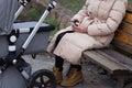 young caucasian mother walking with newborn baby in buggy due to coronavirus covid-19 pandemic lockdown. Business woman Royalty Free Stock Photo