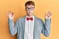 Young caucasian nerd man wearing glasses wearing hipster elegant look with bowtie relax and smiling with eyes closed doing Royalty Free Stock Photo