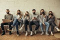 Young people sit together in masks Royalty Free Stock Photo