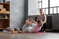 Young caucasian practicing yoga in gym with help of teacher