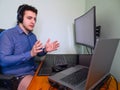 Young caucasian programer man in underwear with headphones talking with his coworkers by a conference call