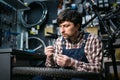 Young caucasian repairman repairing mountain bike wheel in bike shop workshop. Fixing bicycle. Caring for you wheels. man mechanic