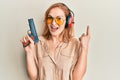 Young caucasian shooter woman using gun smiling with an idea or question pointing finger with happy face, number one