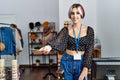 Young caucasian shopkeeper woman smiling happy giving dollars at clothing store