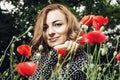 Young caucasian smiling woman with corn poppy flowers, beauty an Royalty Free Stock Photo