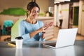 Young Caucasian teacher working with student online while gesturing at the camera of her laptop Royalty Free Stock Photo