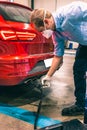 A technician doing an emission control of a security inspection of a vehicle protected with a mask and gloves to prevent the