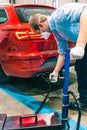 A technician doing an emission control of a security inspection of a vehicle protected with a mask and gloves to prevent the Royalty Free Stock Photo