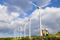 Young engineers looking and checking wind turbines at field Royalty Free Stock Photo