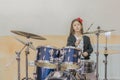 young caucasian teenage girl plays the drums. girl playing the drum set. girl learns to play drums in music school Royalty Free Stock Photo