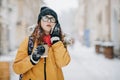 Caucasian teenage woman talking on the phone laughing holding a takeaway coffee cup smiling. Outdoors winter portrait of Royalty Free Stock Photo
