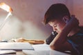 Young Caucasian tired boy learning at evening Royalty Free Stock Photo