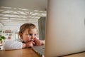 Young caucasian toddler watching computer screen at home