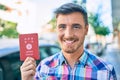 Young caucasian tourist man smiling happy holding japanese passport walking at the city Royalty Free Stock Photo