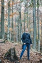 Young caucasian tourist woman is looking around in autumn forest Royalty Free Stock Photo