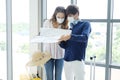 Young Caucasian traveler couple love wear mask for prevention for covid-19 virus is holding map find location for travel in the