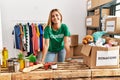 Young caucasian volunteer girl smiling happy standing at charity center