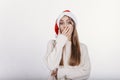 Young caucasian white woman in santa hat covering her mouth by hand Royalty Free Stock Photo