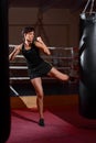 A young Caucasian woman actively trains in the gym and do boxing exercises in boxing gloves in front of a punching bag Royalty Free Stock Photo