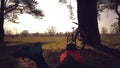 Young caucasian woman athlete tourist cyclist makes photo on phone, photographs his bike standing near tree on nature