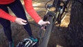 Young caucasian woman athlete tourist cyclist uses a hand tool, a bicycle pump to inflate air into a tire wheel mountain bike. Royalty Free Stock Photo