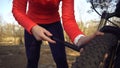 Young caucasian woman athlete tourist cyclist uses a hand tool, a bicycle pump to inflate air into a tire wheel mountain bike. Royalty Free Stock Photo