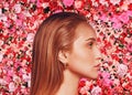 Young caucasian woman beauty profile portrait on pink and red roses flowers wall background Royalty Free Stock Photo
