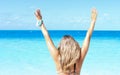 Young blonde woman raising her Arms on the beach