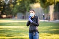 Young Caucasian woman in black leather jacket and surgical mask takes on purple latex gloves Royalty Free Stock Photo