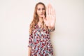 Young caucasian woman with blond hair wearing summer dress doing stop sing with palm of the hand Royalty Free Stock Photo