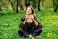 Young caucasian woman with book on meadow with dandelions.