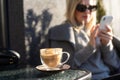 Young caucasian woman business woman drinks coffee at coffee shop terrace