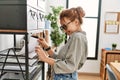 Young caucasian woman business worker holding document of shelving at office