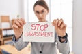 Young caucasian woman business worker holding stop harassment message banner at office