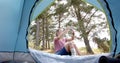 Young Caucasian woman captures a moment with her phone inside a tent