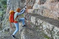 Tourist walking around Fethiye in Turkey, young European woman climbs stairs to Amyntas Rock Tombs using hiking poles. Royalty Free Stock Photo