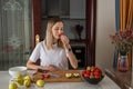 Young caucasian woman cooking fresh fruit and vegetable salad on table. Person preparing healthy yummy eating lunch in Royalty Free Stock Photo