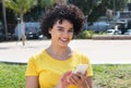 Young caucasian woman with curly hair sending message with mobil Royalty Free Stock Photo