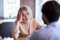 Young Caucasian woman disinterested in blind date, feeling bored with conversation at city cafe Royalty Free Stock Photo