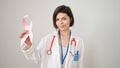 Young caucasian woman doctor holding breast cancer awareness pink ribbon over isolated white background Royalty Free Stock Photo